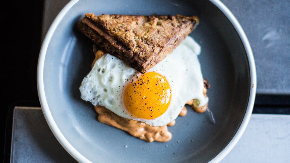 Delicious breakfast served at Deskplex Office Space Hawthorn Richmond Abbotsford, featuring a fried egg with a savory sandwich on a modern plate