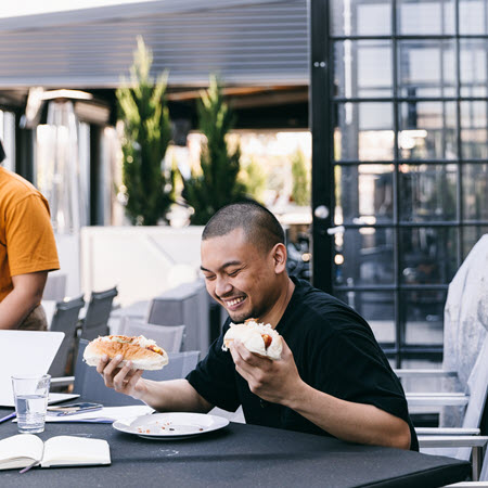 Outdoor seating at Deskplex Office Space Hawthorn Richmond Abbotsford, featuring modern tables, cushioned chairs, and surrounding plants, creating a relaxed yet professional environment