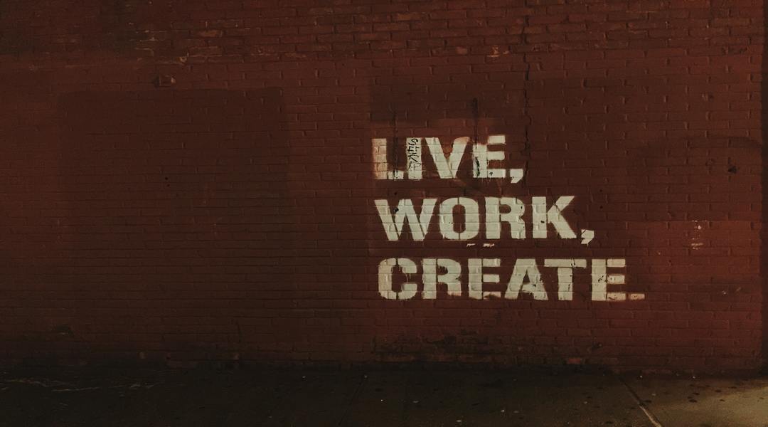 Brick wall with live work create painted on it