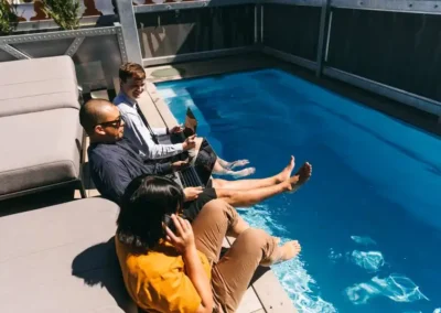 Members working beside the outdoor pool at DeskPlex Hawthorn, highlighting the flexible work environment and premium lifestyle amenities available alongside private offices, coworking spaces and meeting facilities.