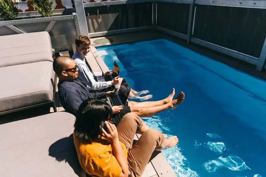Members working beside the outdoor pool at DeskPlex Hawthorn, highlighting the flexible work environment and premium lifestyle amenities available alongside private offices, coworking spaces and meeting facilities.